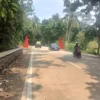 KECIL: Pengendara tengah melintasi tugu batas Desa Cibeureuyeuh dan Narimbang di Kecamatan Conggeang, yang dinilai berukuran sangat kecil dan disayangkan warga, baru-baru ini.