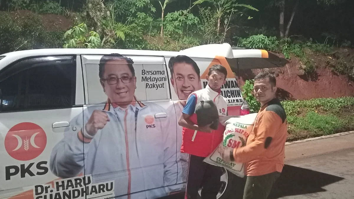 Ketua DPD Partai Keadilan Sejahtera (PKS) Sumedang Yana Flandriana membagian bantuan beras pada korban bencana