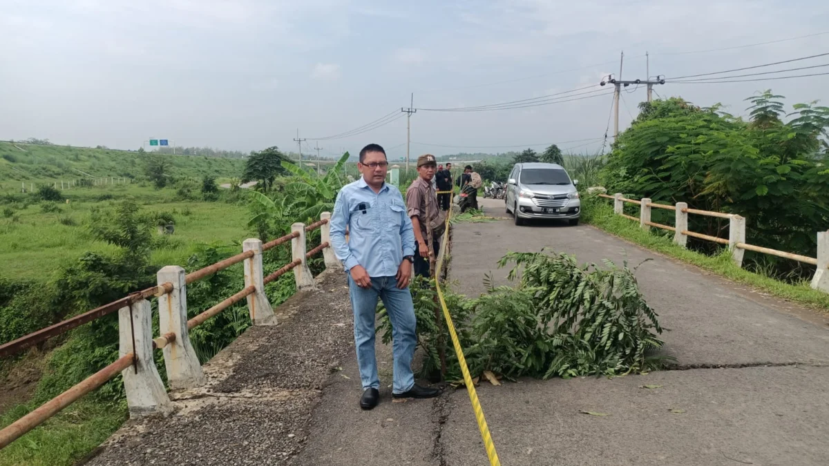 PASANG: Kepala UPTD PUTR Wilayah Tomo Teguh saat memantau pemasangan police line di Sasak Beureum bersama unsur lainnya, kemarin.