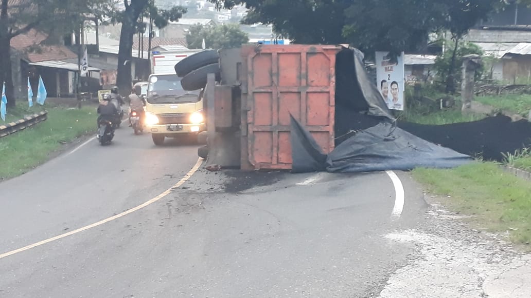 BERHAMBURAN: Kondisi truk bermuatan batubara pasca terguling di Tikungan Ciromed Tanjungsari, Sumedang, kemarin.