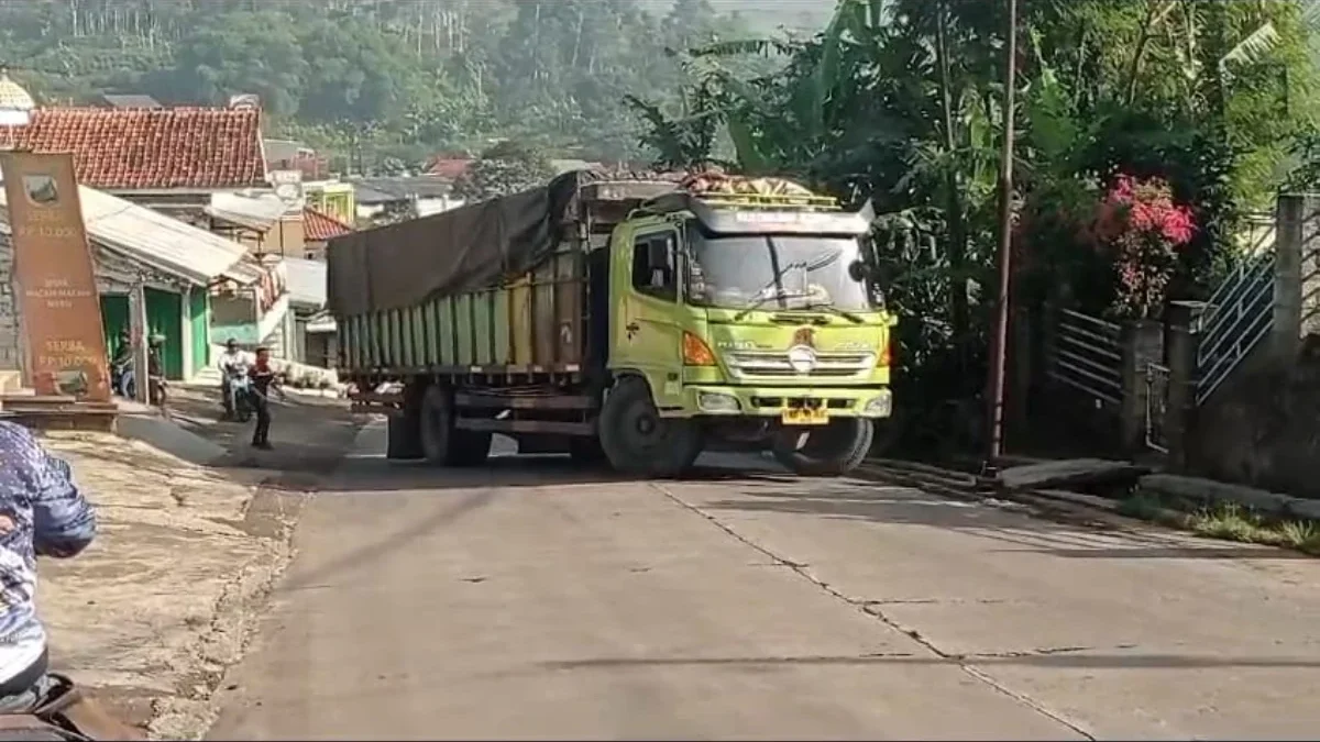 WASWA: Beberapa warga saat berupaya mencegah tronton terguling saat di tanjakan akibat kelebihan muatan di sek