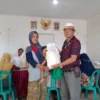 SIMBOLIS: Simbolis penyerahan beras 10 Kg oleh Kepala Desa Padasuka, Gamis kepada salah seorang warga yang merupakan KPM di Desa Padasuka, baru-baru ini.