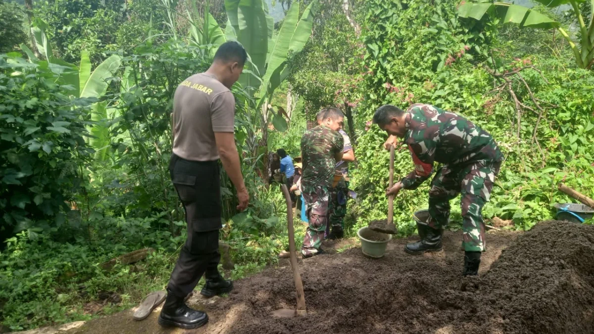 BEJIBAKU: Anggota Koramil 1001 Smd Utara bersama Bhabinkamtibmas dan masyarakat setempat bahu membahu mengangk