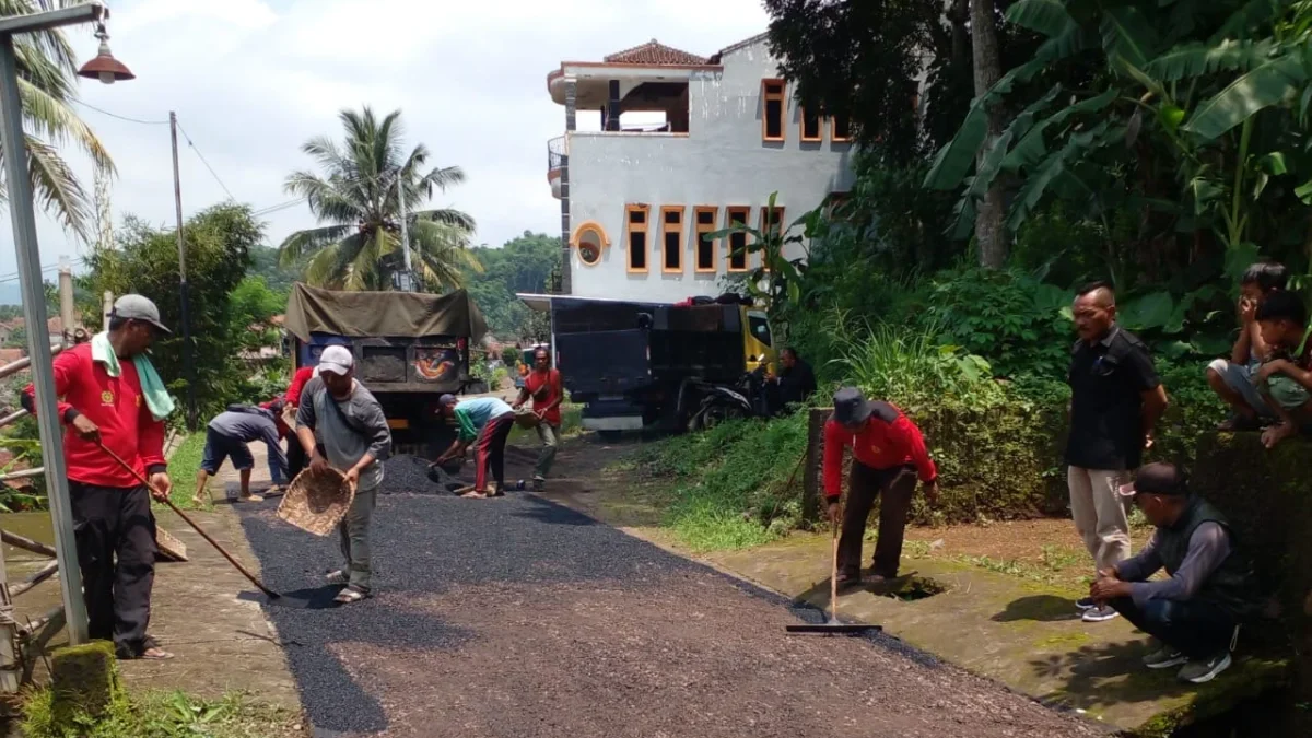 PENUH HARAP: Kepala Desa Kebonjati Jajang (Kanan) bersama Kadus II Asep, saat monitoring pengaspalan Jalan Gi