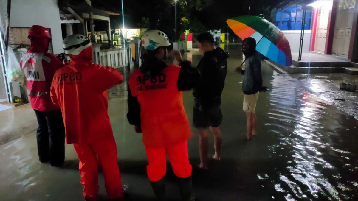 Petugas BPBD Kabupaten Sumedang dibantu aparat setempat menangani banjir di Kecamatan Tomo, Selasa (5/3/2024)