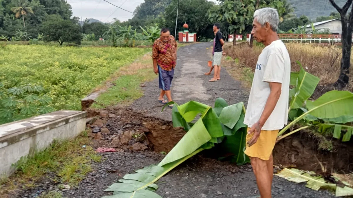 WASPADA: Seorang warga Desa Jembarwangi saat melihat jembatan anak Sungai Cisaar Lanang yang amblas, kemarin.