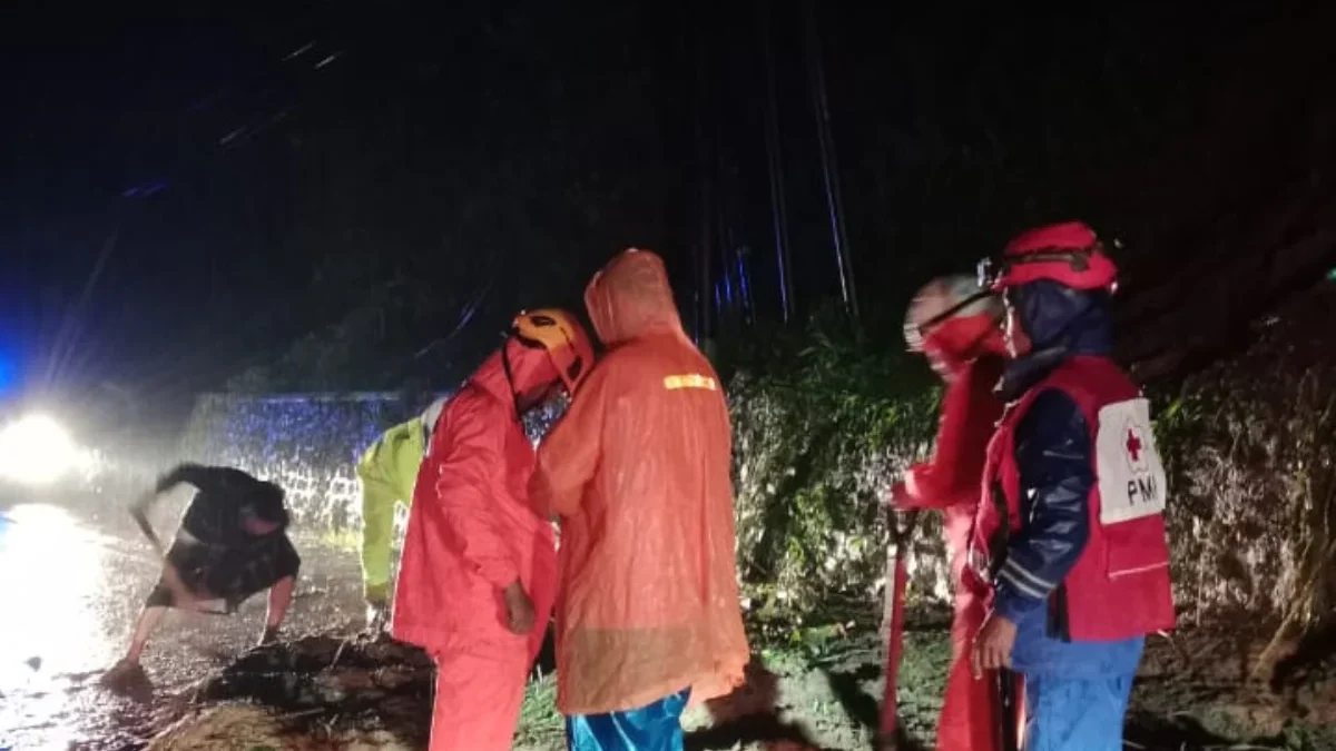 TANGANI: Petugas BPBD Sumedang melakukan penanganan longsor yang menutup jalan Sumedang Bandung di Blok Cigend