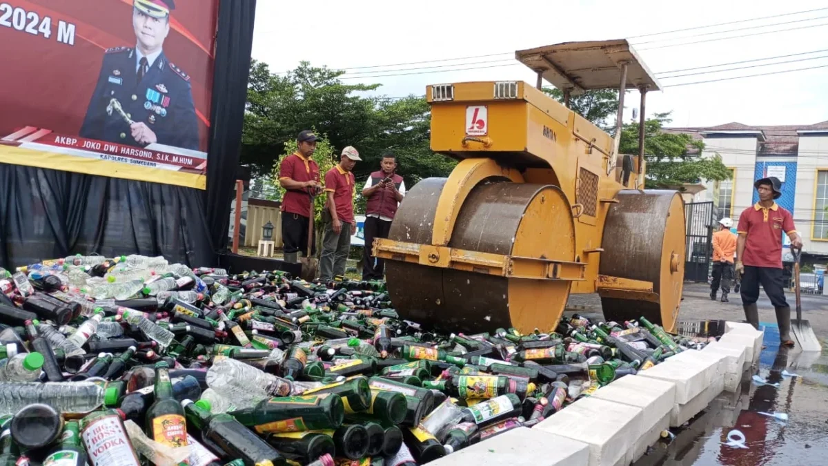 MUSNAH: Satu unit stoom walls sedang melindas ribuan botol minuman keras, di lapang upacara Mapolres Sumedang,