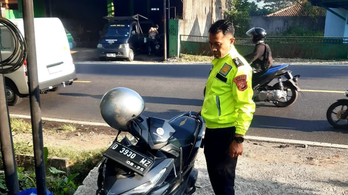 PERIKSA: Anggota Kapolsek Bripka Arya NugrahaJatinangor saat mengecek motor korban di Jatinangor, Jumat (21/6