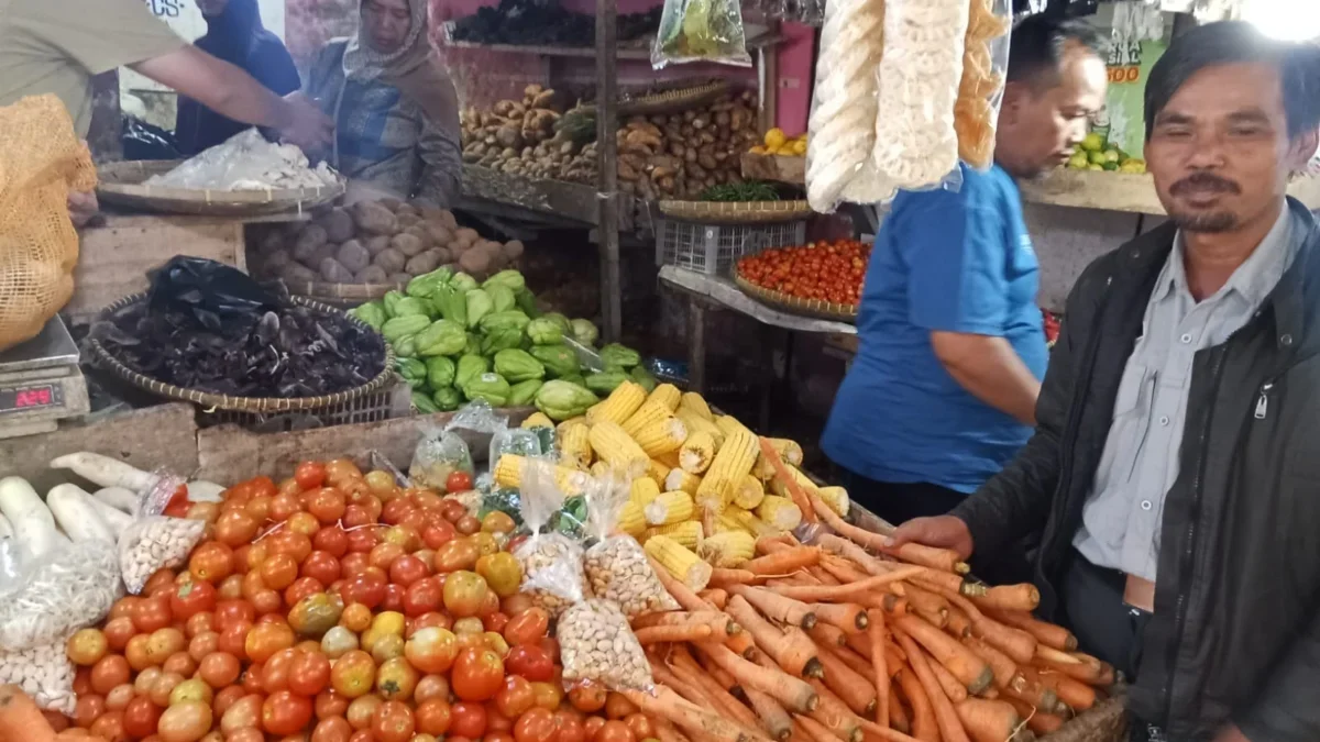 PANTAU: Petugas pasar Parakanmuncang saat memantau harga kebutuhan pokok di salah satu pedagang sayuran, Selas