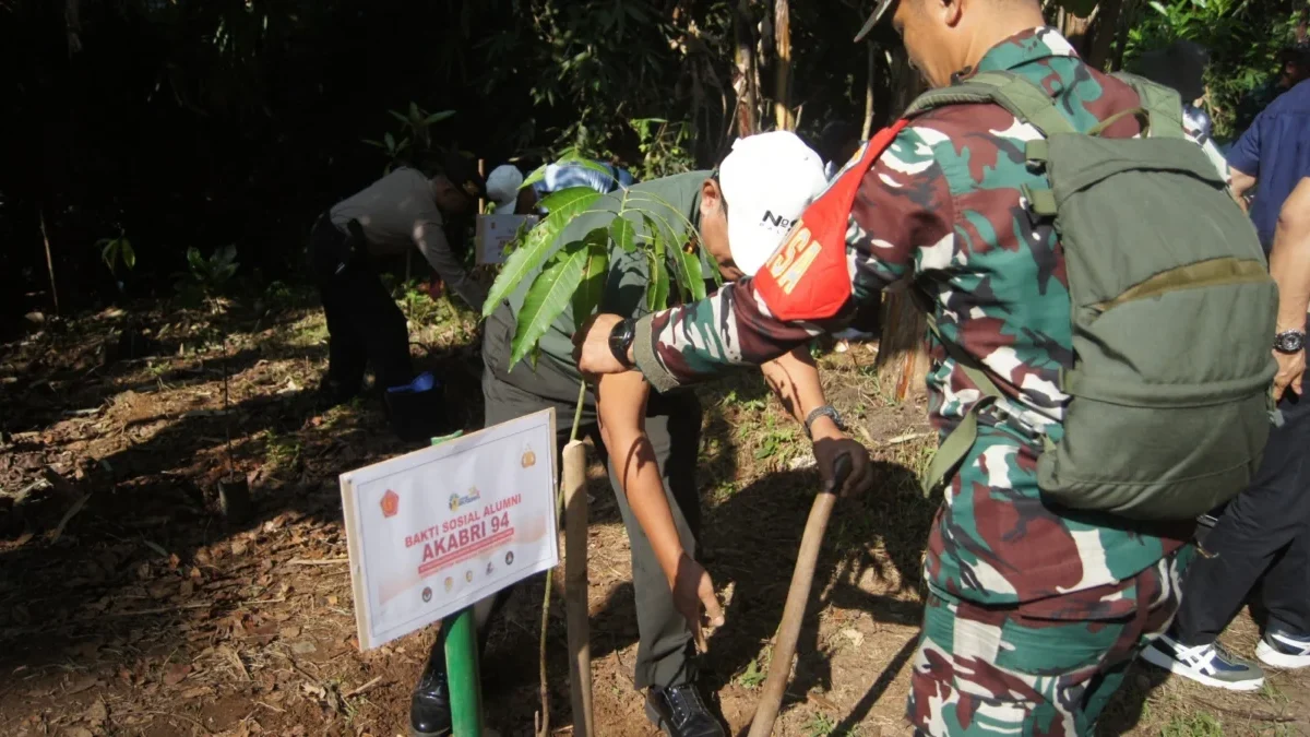 TANAM: Salah satu personil TNI saat melakukan penanaman pohon di Desa Ciherang, Rabu (5/6).