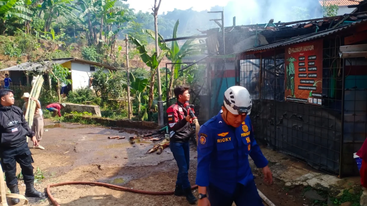 PADAMKAN: Petugas Pemadam Kebakaran UPT Damkar wilayah Tanjungsari pada saat memadamkan api di sebuah bengkel