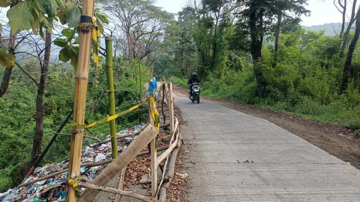 RUSAK: Seorang warga saat melintas di jalan Hariang-Wanajaya yang mengalami kerusakan parah, baru-baru ini.