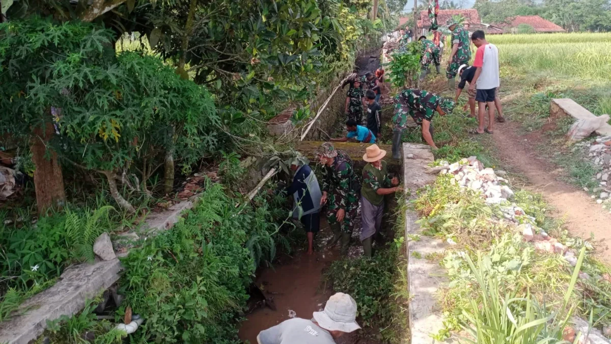 BERSIHKAN: Anggota Koramil Situraja beserta elemen masyarakat melaksanakan Karya bakti pembersihan saluran iri