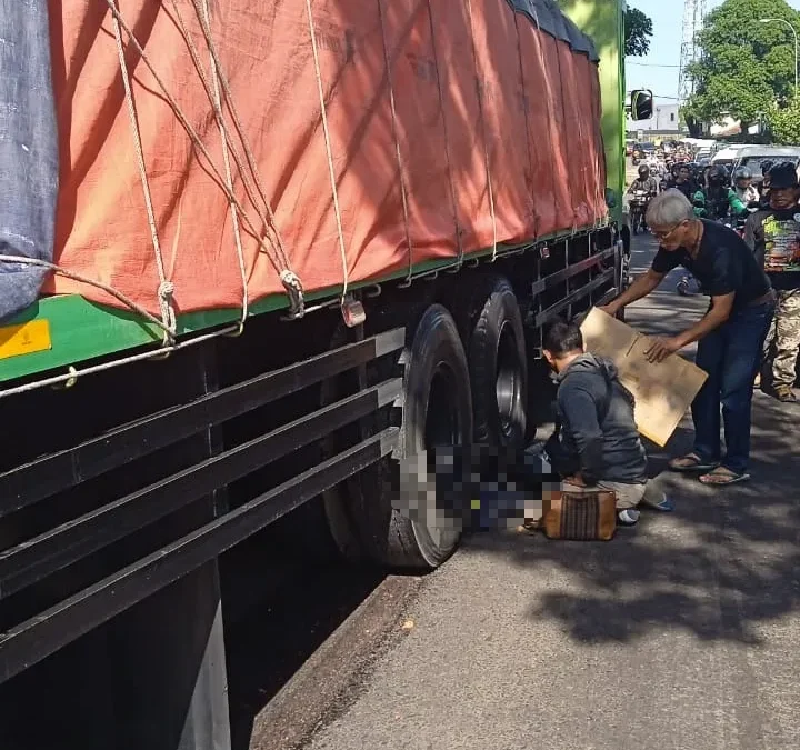 TEWAS: Korban kecelakaan Susi Hadianti saat hendak dievakuasi di bawah mobil truk fuso di Jatinangor, Minggu (