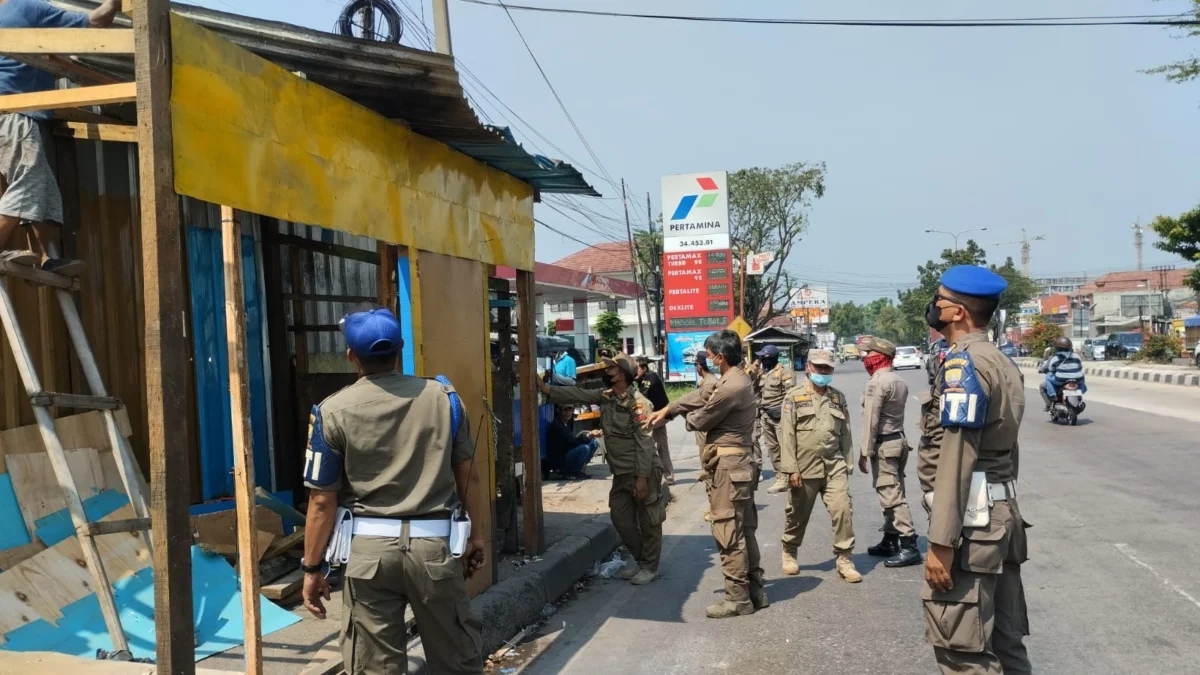 ROBOHKAN: Petugas Satpol PP Kabupaten Sumedang saat melakukan pembokaran bangunan liar di Jalan Raya Bandung-G