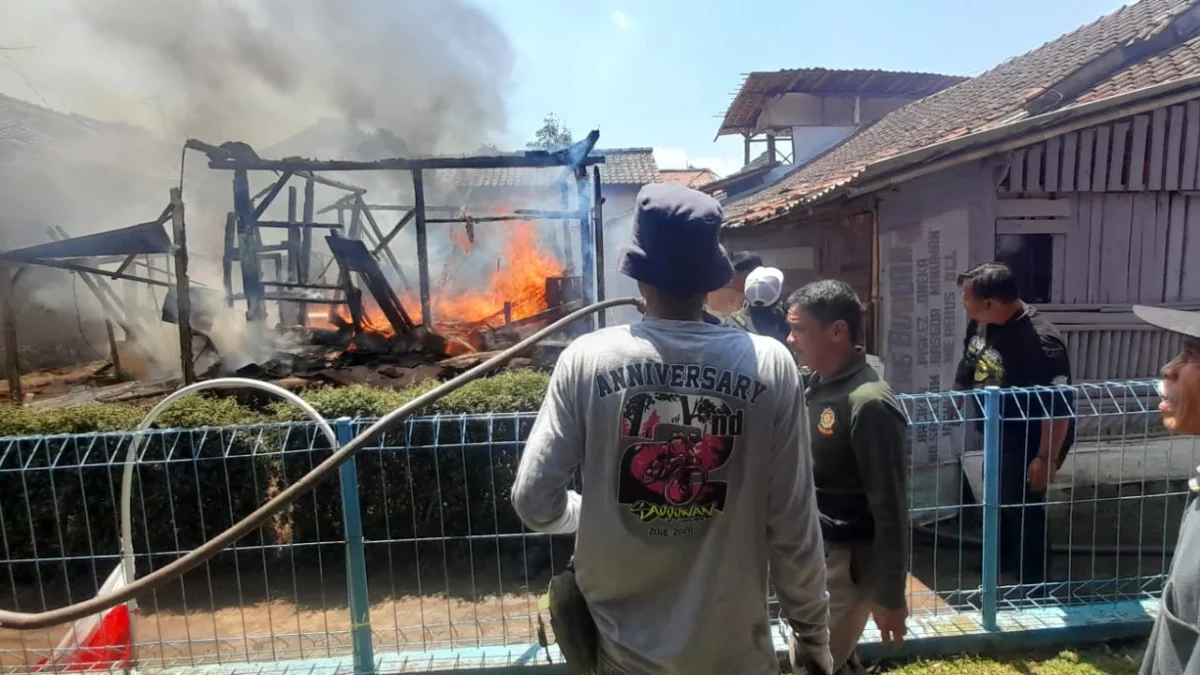 PADAMKAN: Para petugas pemadam kebakaran saat berusaha memadamkan api yang membakar sebuah rumah di Tanjungsar