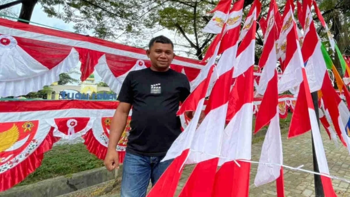 BERJUALA: Pedagang bendera dan pernak-pernik Agustusan Endi saat berbincang dengan Sumeks mengenai penjualan,