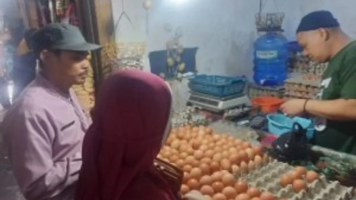 BERJUALAN: Salah satu pedagang telur di Pasar Tradisional Tanjungsari Hamdan saat melayani pembeli, baru-baru