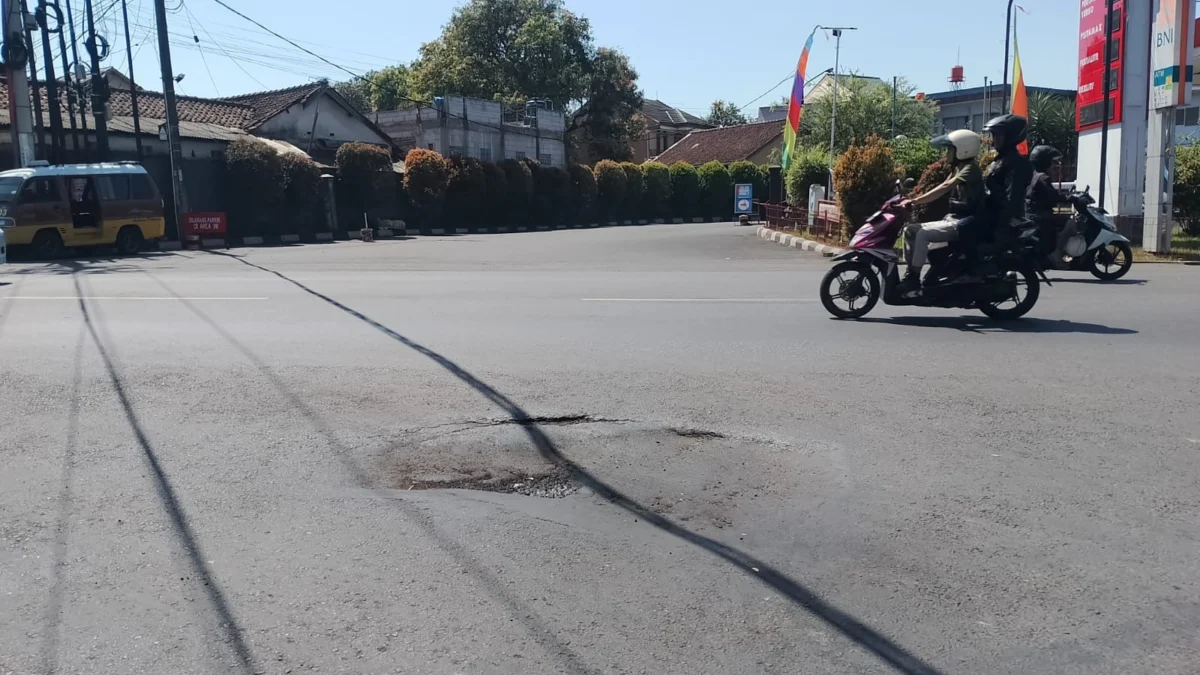 RUSAK: Kondisi jalan berlubang yang membahayakan pengendara di samping Tugu Tahu, Selasa (13/8).