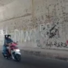 VANDALISME: Coretan di dinding bawah jembatan Desa Mekarjaya yang membuat resah warga setempat.