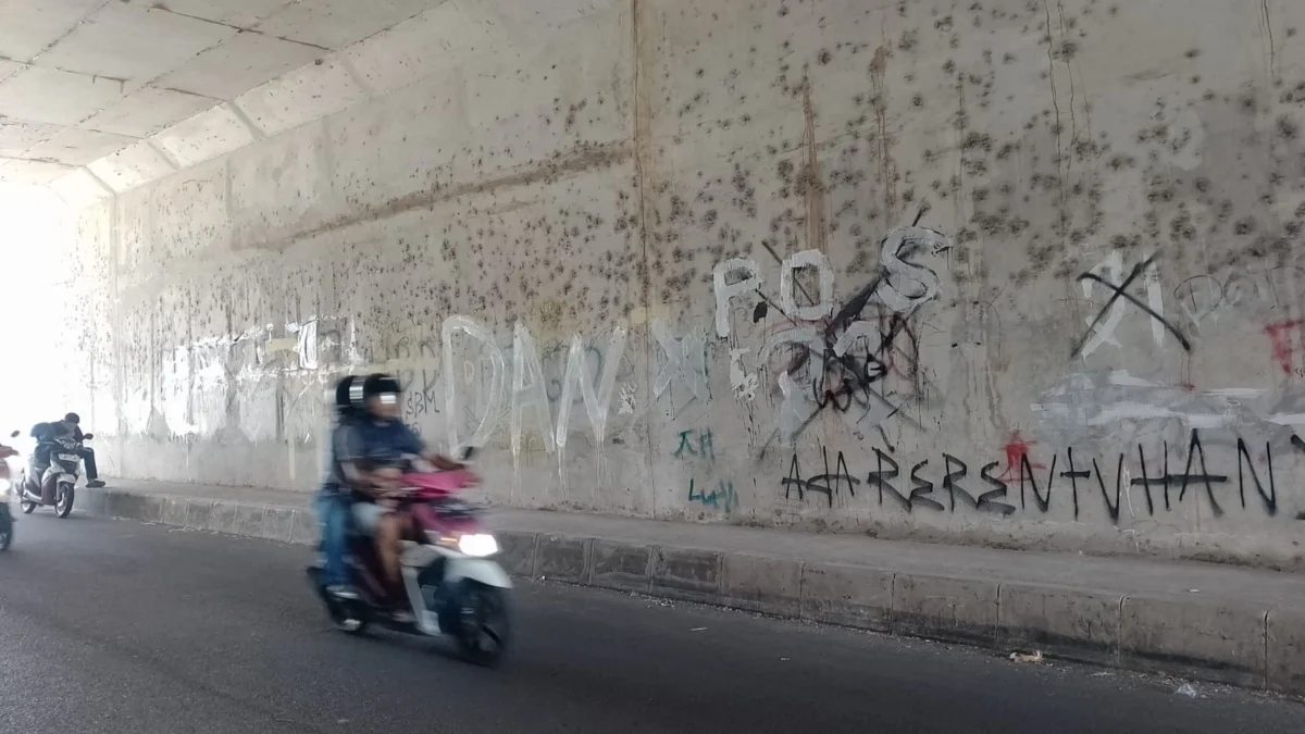 VANDALISME: Coretan di dinding bawah jembatan Desa Mekarjaya yang membuat resah warga setempat.