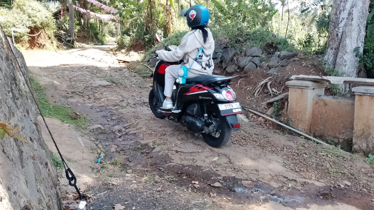 LEWATI: Salah satu pengendara saat melintas di jalan lingkungan Perum Giri Mukti, Sumedang Selatan, Senin (19/