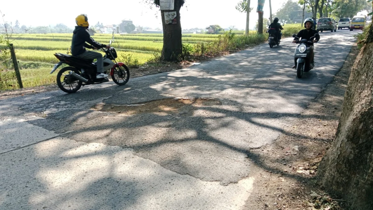 LEWATI: Sejumlah pengendara bermotor saat melintasi jalan berlubang di terusan jalan Padasuka, Kecamatan Sumed