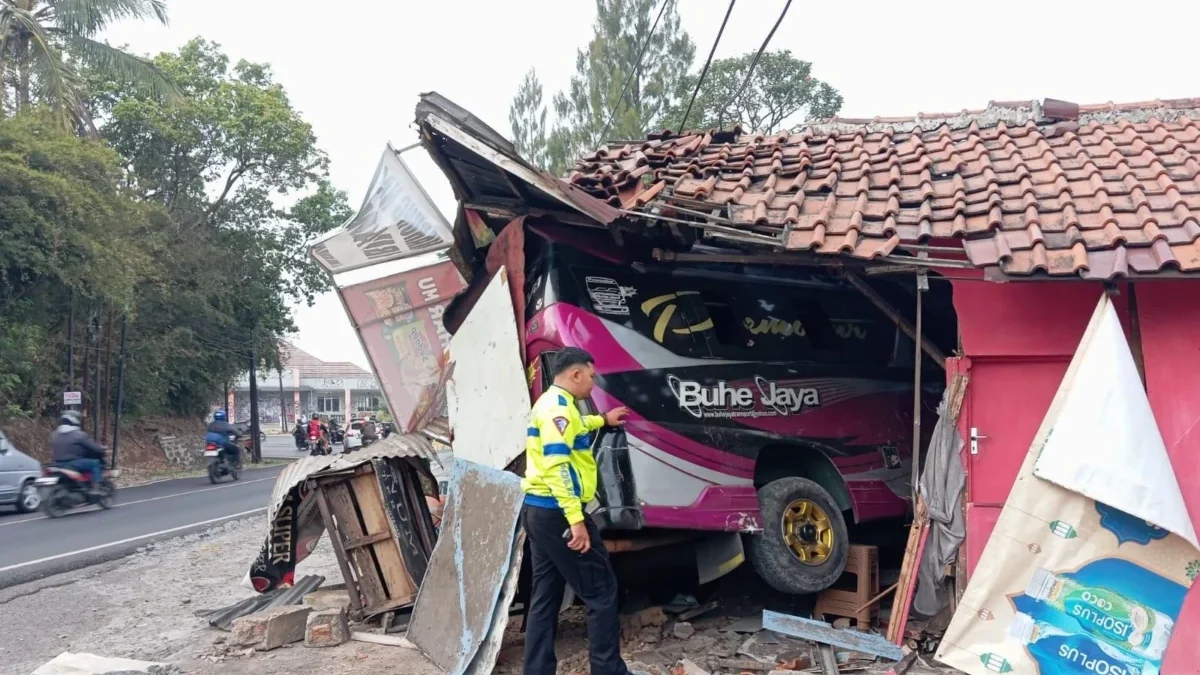 KECELAKAAN: Elf Buhe mengalami pecah ban dan akhirnya oleng menabrak warung di Kecamatan Jatinangor, Senin (2/