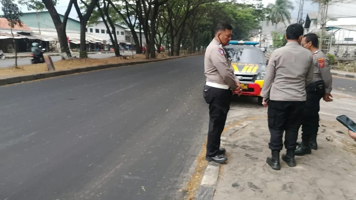 INVESTIGASI: Aparat Polisi saat melakukan pengecekan jalanan yang licin di Jalan Raya Bandung-Garut Kecamatan