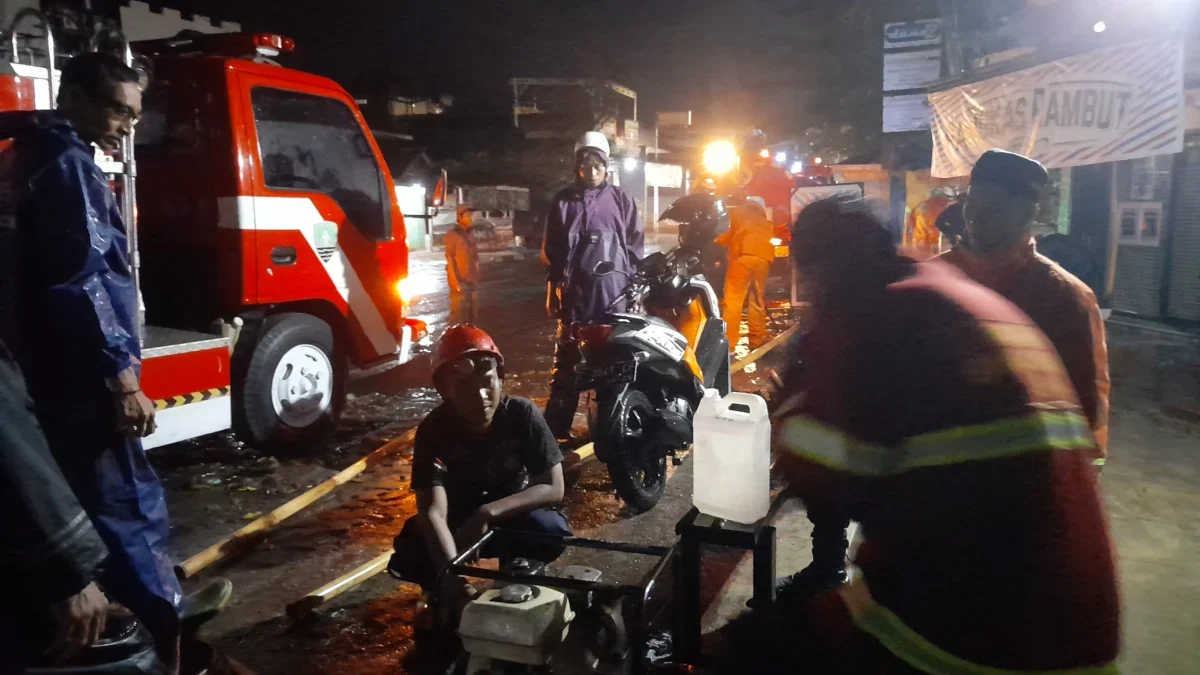 TANGANI: Anggota Damkar Wilayah Kota langsung melakukan penanganan banjir pada salah satu rumah warga di Kelur