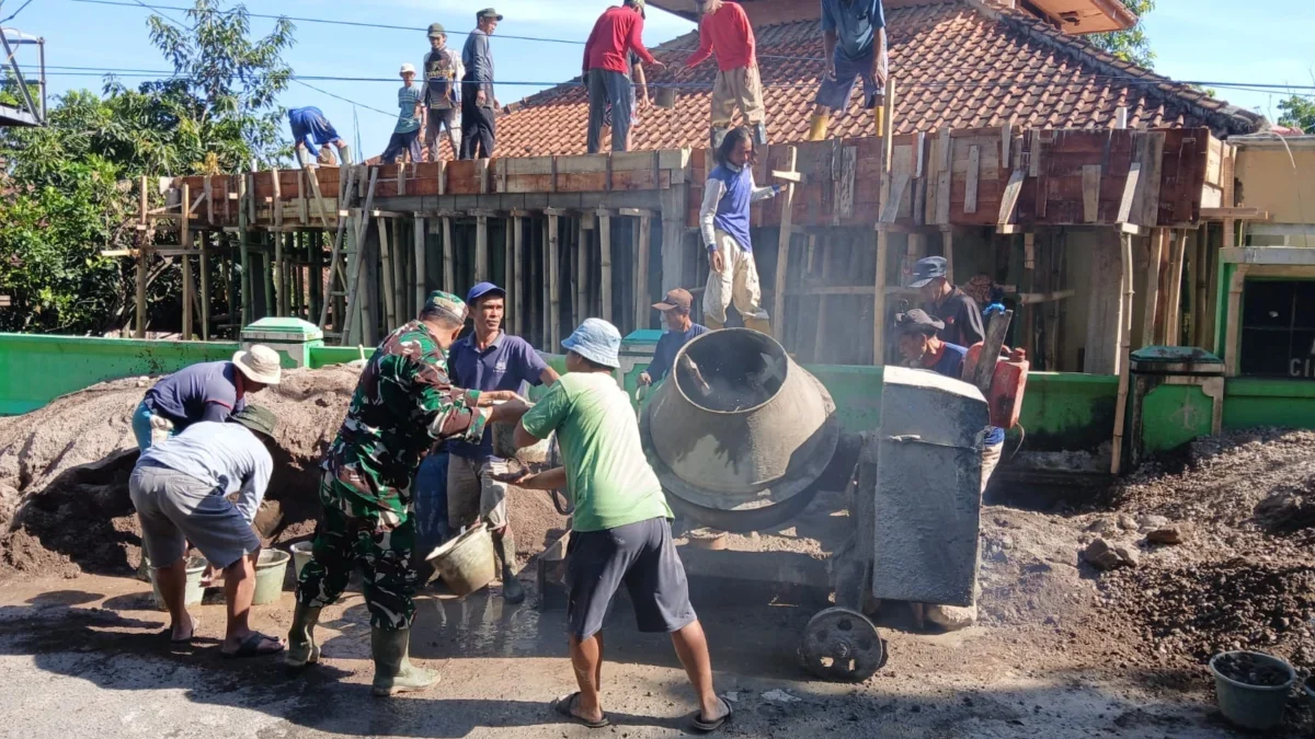 GOTONG ROYONG: Babinsa Desa Kertaharja Sertu Endang Kustian saat membantu warga membangun masjid, baru-baru in