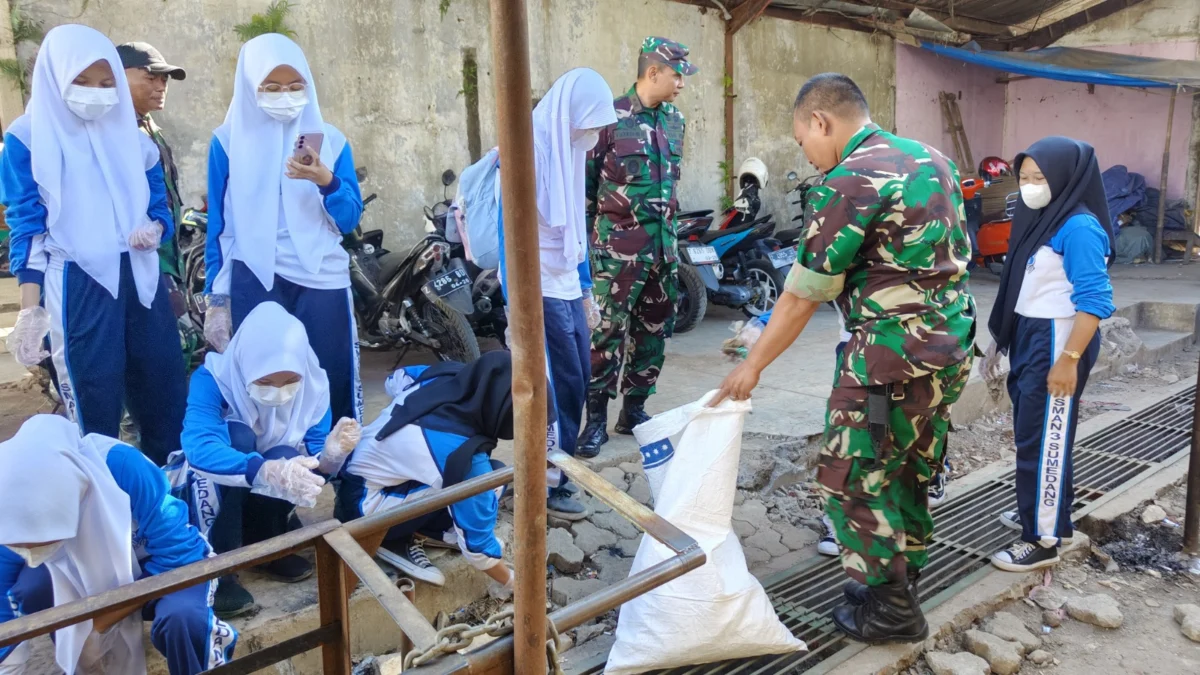 BERSAMA: TNI bersama siswa saat melakukan pembersihan di Pasar Sandang Kabupaen Sumedang, Rabu (18/9).