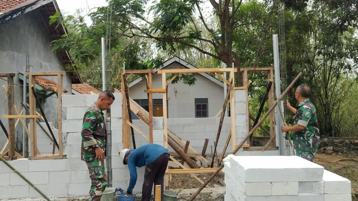 GOTONG ROYONG: Babinsa Desa Cipeles Sertu Hasan Subandi saat membantu program Rutilahu di Kecamatan Tomo, Seni