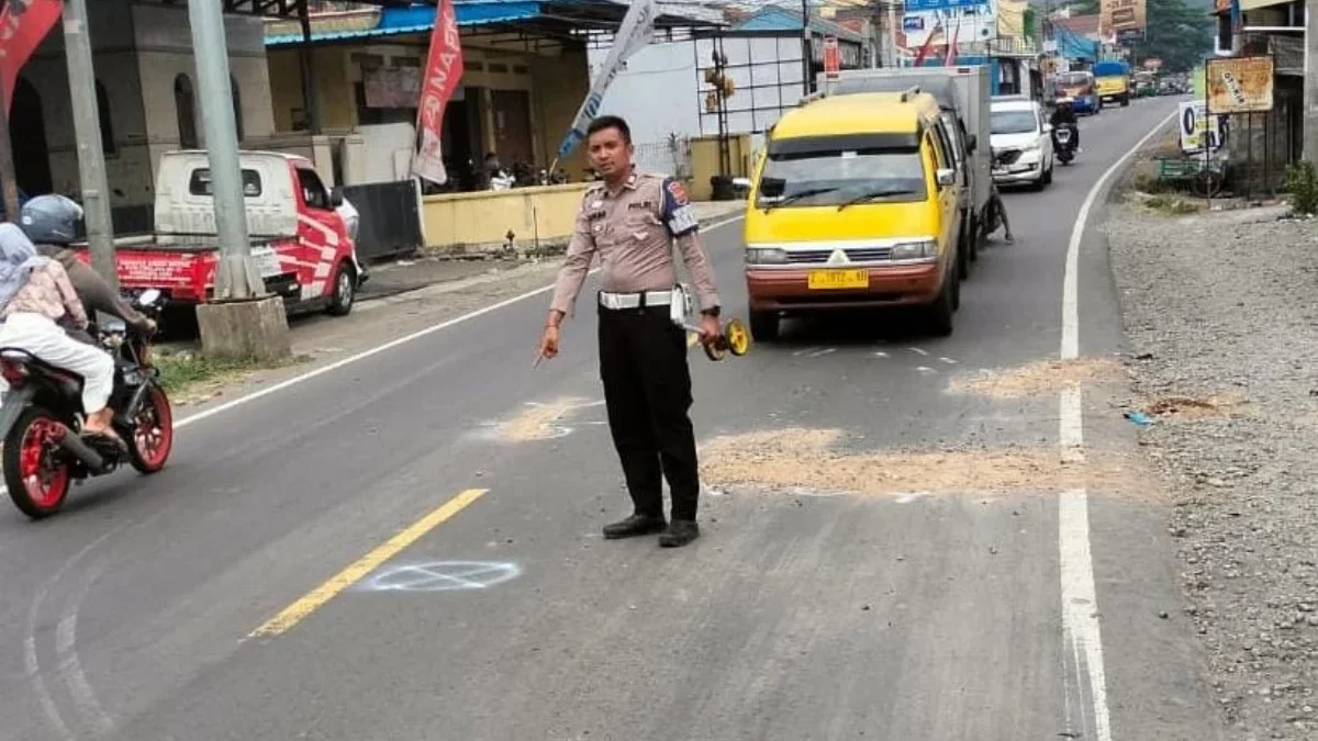 TUNJUKKAN: Anggota Unit Laka Polres Sumedang menunjukkan lokasi tabrakandi Kecamatan Cimalaka, Selasa (25/9).