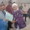 BERIKAN: Kepala Desa Pasirnanjung, Susi Herawati secara simbolis saat menyerahkan sertifikat tanah program PTS