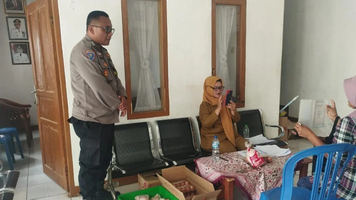 PASTIKAN: Bhabinkamtibmas Desa Pasirnanjung, Bripka Mochamad Gian Pratama, memantau secara langsung pembagian