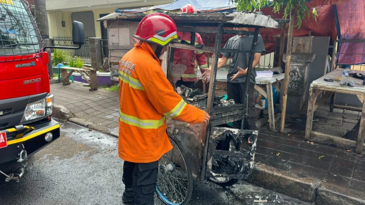 PERIKSA: Petugas Damkar Sumedang Kota saat memeriksa roda jualan cireng milik Oma Karoma (34) yang terbakar, K