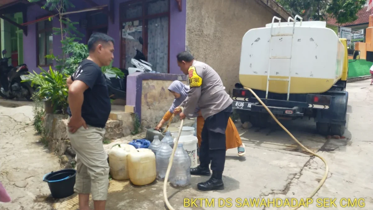 BANTU WARGA: Babhinkamtibmas Desa Sawahdadap saat menyalurkan bantuan air bersih, kemarin.