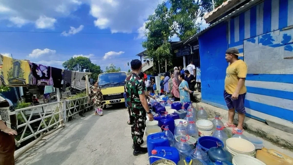 KEKERINGAN: Babinsa Koramil Cimanggung Sertu Budy saat bantu warga atasi krisis air bersih di Desa Sawahdadap