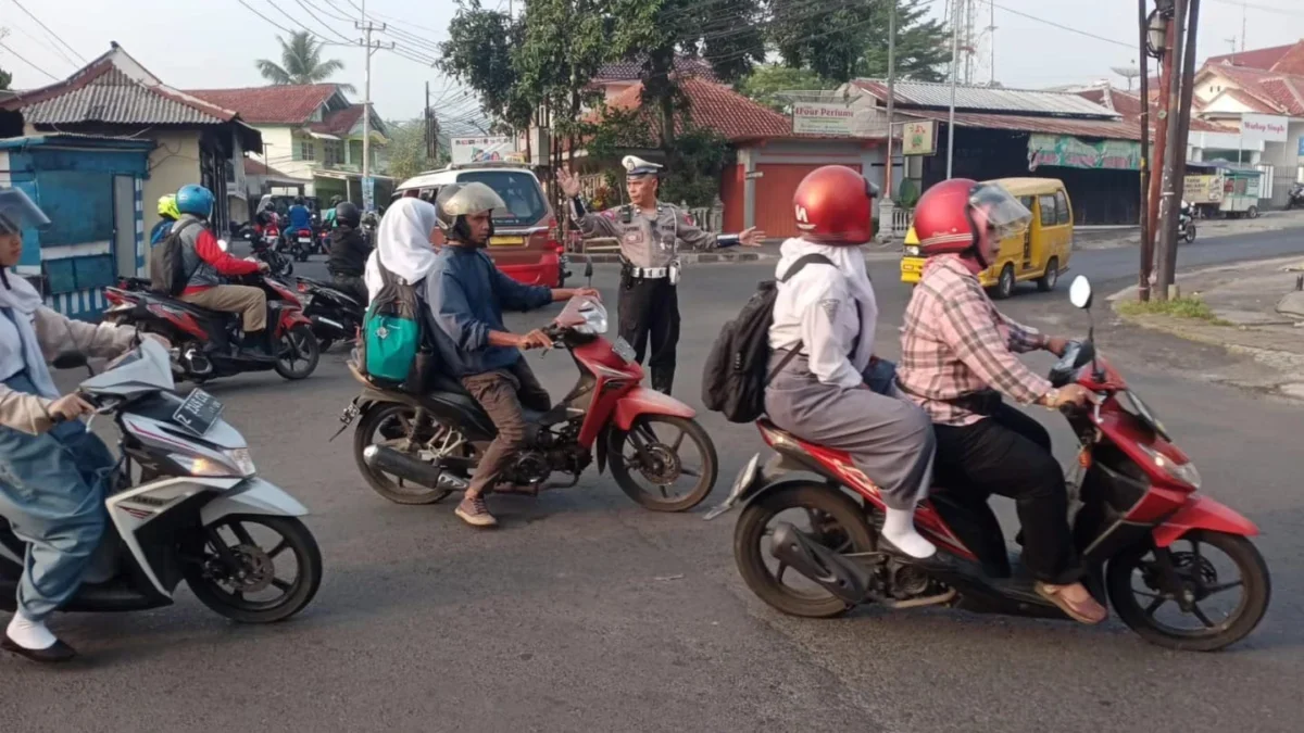 AMANKAN: iptu Pepen Apendi saat mengatur lalulintas di Jalan Kartini Keluraha Cipamempeuk, kemarin.