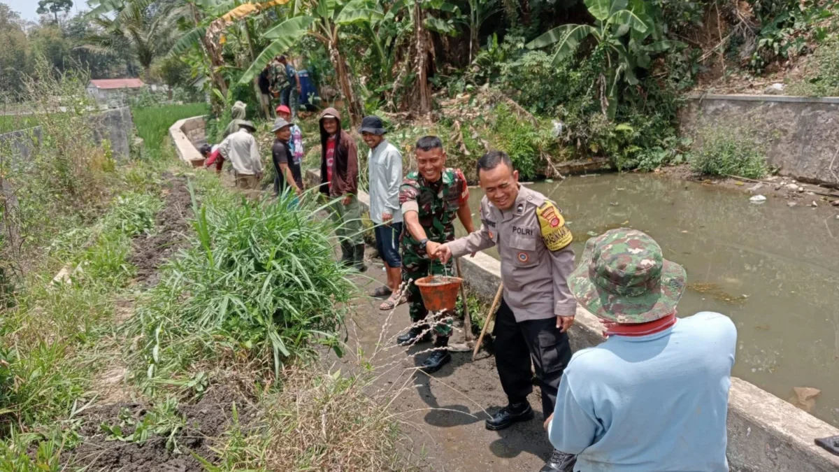 GOTONG ROYONG: Babinsa Desa Nyalindung, Serda Aris Setiyanto, saat kegiatan karya bakti bersama warga dalam pe