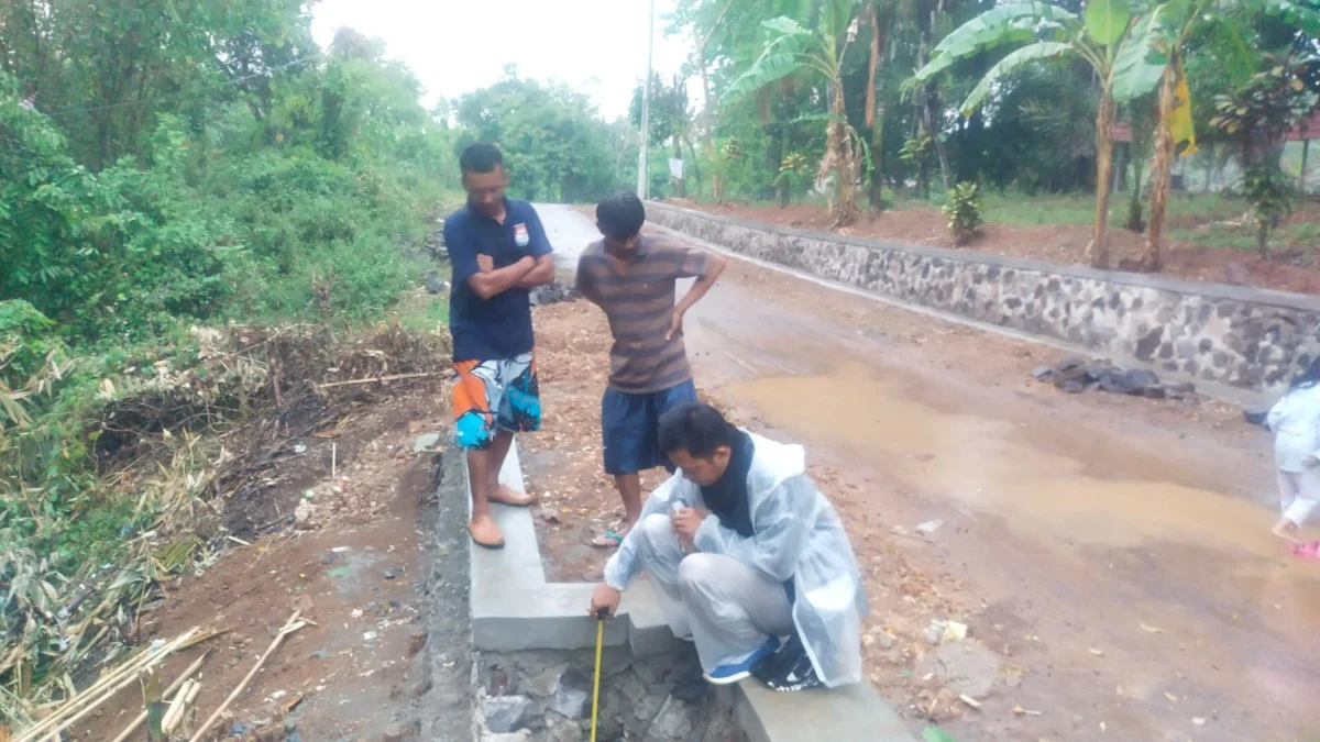 MENGUKUR: Beberapa warga saat melihat TPT di Dusun/Desa Ciawitali Kecamatan Buahdua, baru-baru ini.