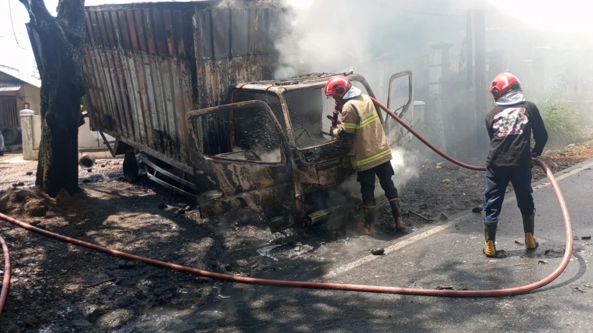 HANGUS: Petugas pemadam kebakaran saat memadam mobil box yang terbakar di Desa Padanaan Kecamatan Paseh, Mingg