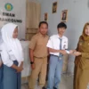 PERMUDAH: Kasi Pelayanan Publik Kecamatan Cimanggung, Ai Toyaidah saat penyerahan KTP kepada pemilih pemula di