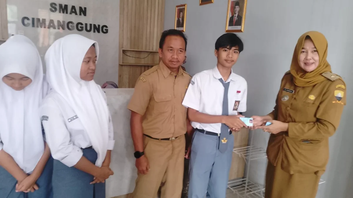 PERMUDAH: Kasi Pelayanan Publik Kecamatan Cimanggung, Ai Toyaidah saat penyerahan KTP kepada pemilih pemula di