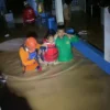 SELAMATKAN: Petugan BPBD saat melakukan evakuasi korban banjir di Kecamatan Banjaran, Rabu (6/11) dini hari.