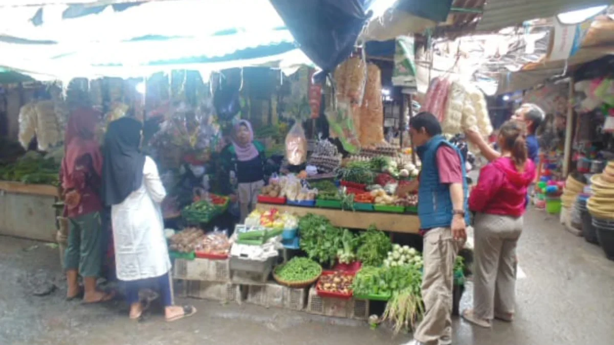 MELONJAK: Pedagang sayuran di Pasar Inpres Sumedang saat melayani pembeli, baru-baru ini.