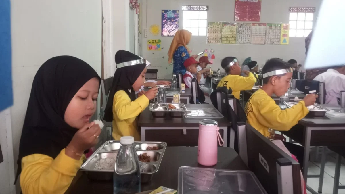 OPTIMALKAN: Sejumlah siswa sekolah dasar saat menyantap makan siang bergizi gratis di sekolahnya, baru-baru in