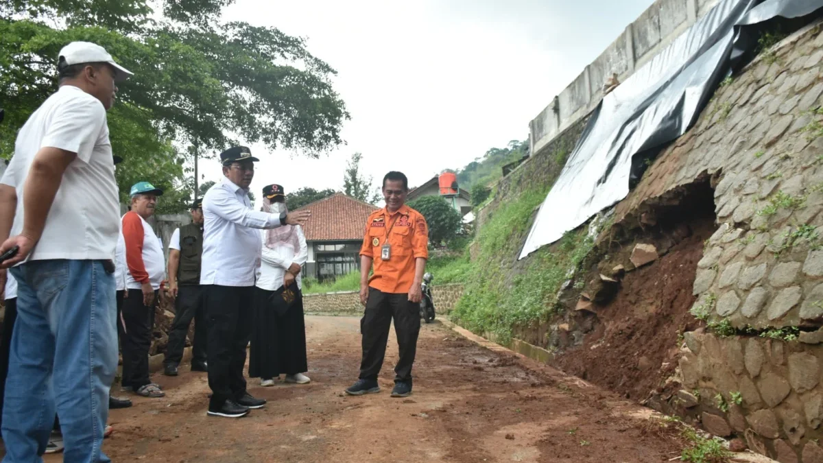 LONGSOR: Pj Bupati Sumedang Yudia Ramli saat meninjau Tembok Penahan Tebing (TPT) yang ambrol di Kelurahan Kot